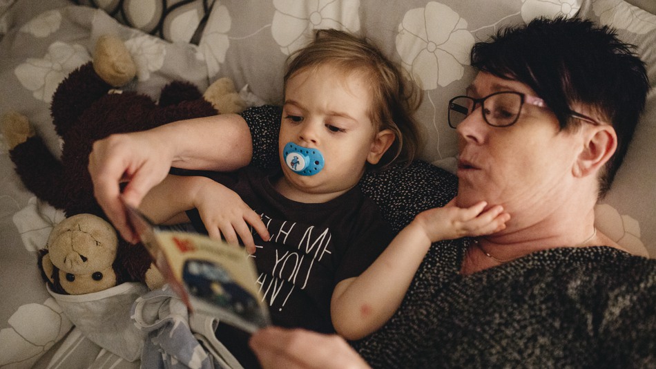 Mormor och barnbarn läser saga